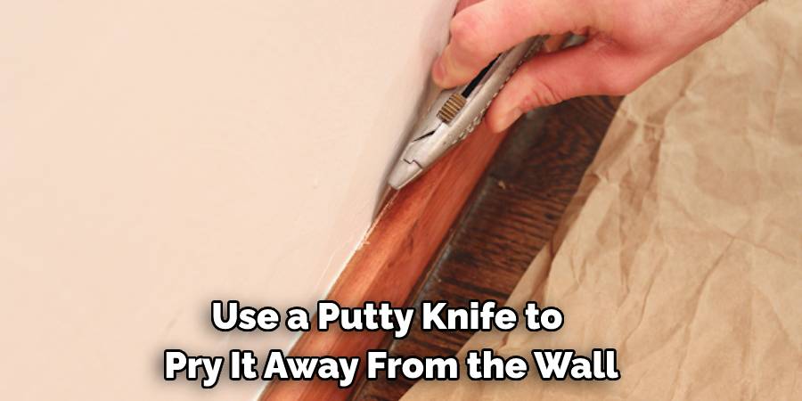 Use a Putty Knife to 
Pry It Away From the Wall