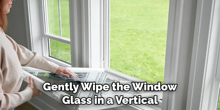 Gently Wipe the Window Glass in a Vertical